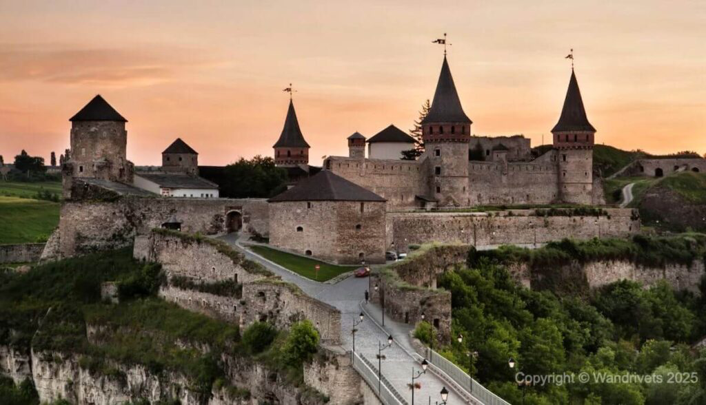 Kamianets-Podilskyi Fortress, lit up at night, overlooking the Smotrych River canyon